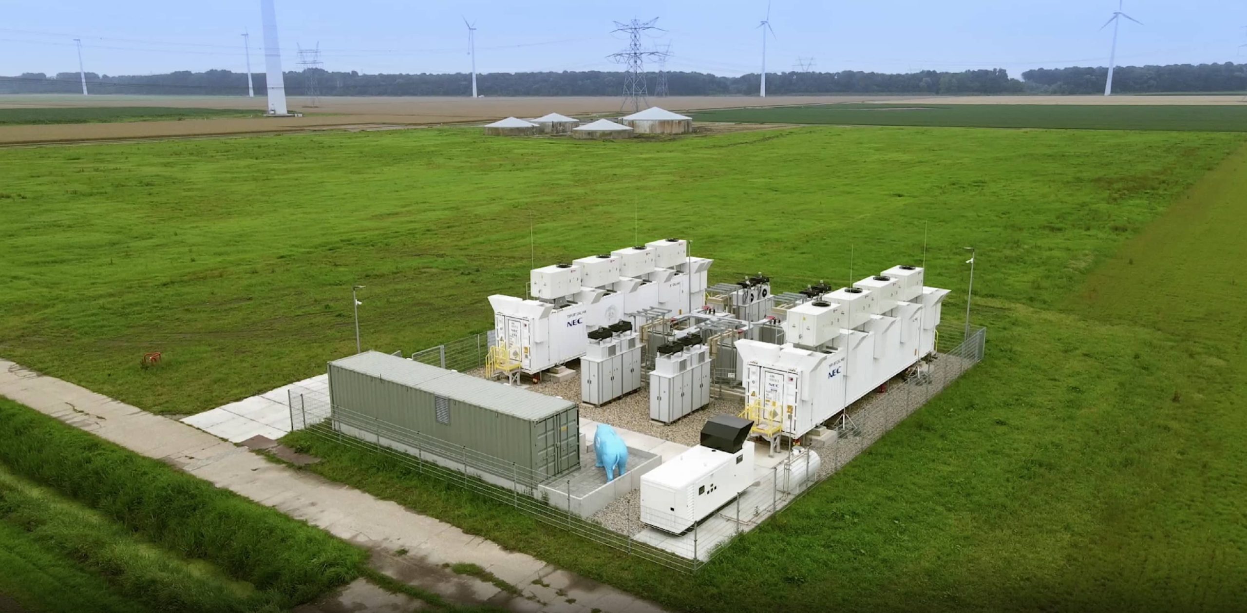 an aerial view of a green field with a lot of power lines.