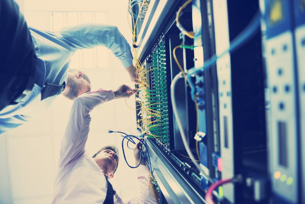 a man standing in front of a server in a server room.