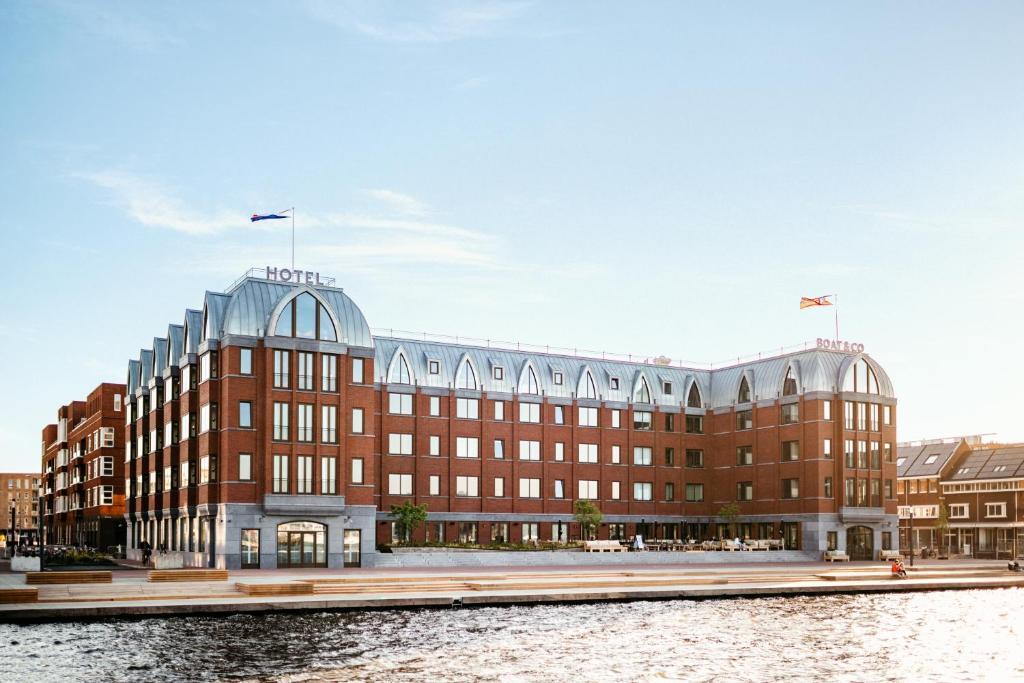 a large red brick building next to a body of water.